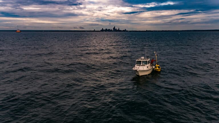 Freeboard technician deploying smart buoy in Lake Erie near Cleveland, Ohio to monitor water quality.